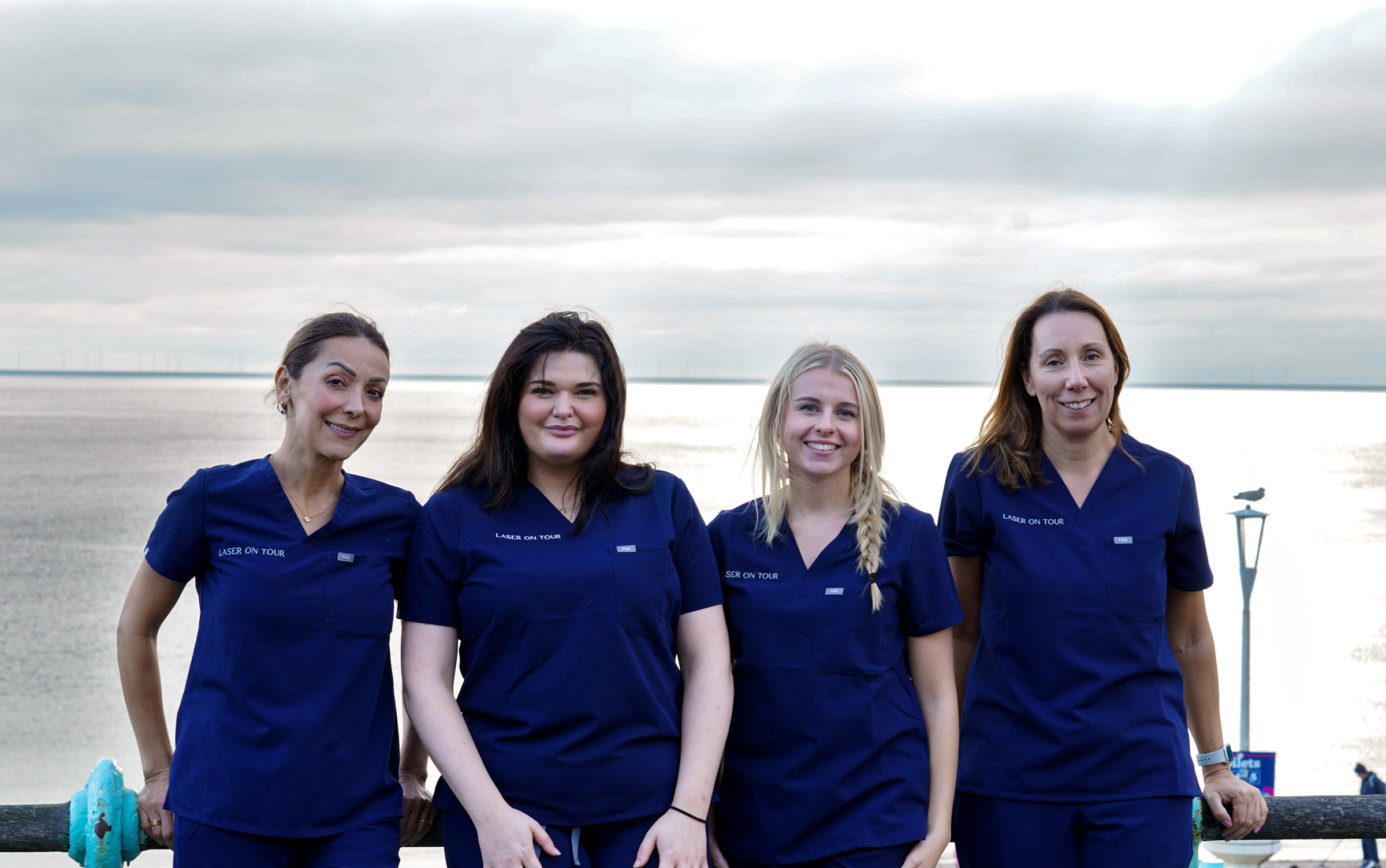 A photo of some of Laser On Tour's laser specialists standing in front of the sea at Brighton.