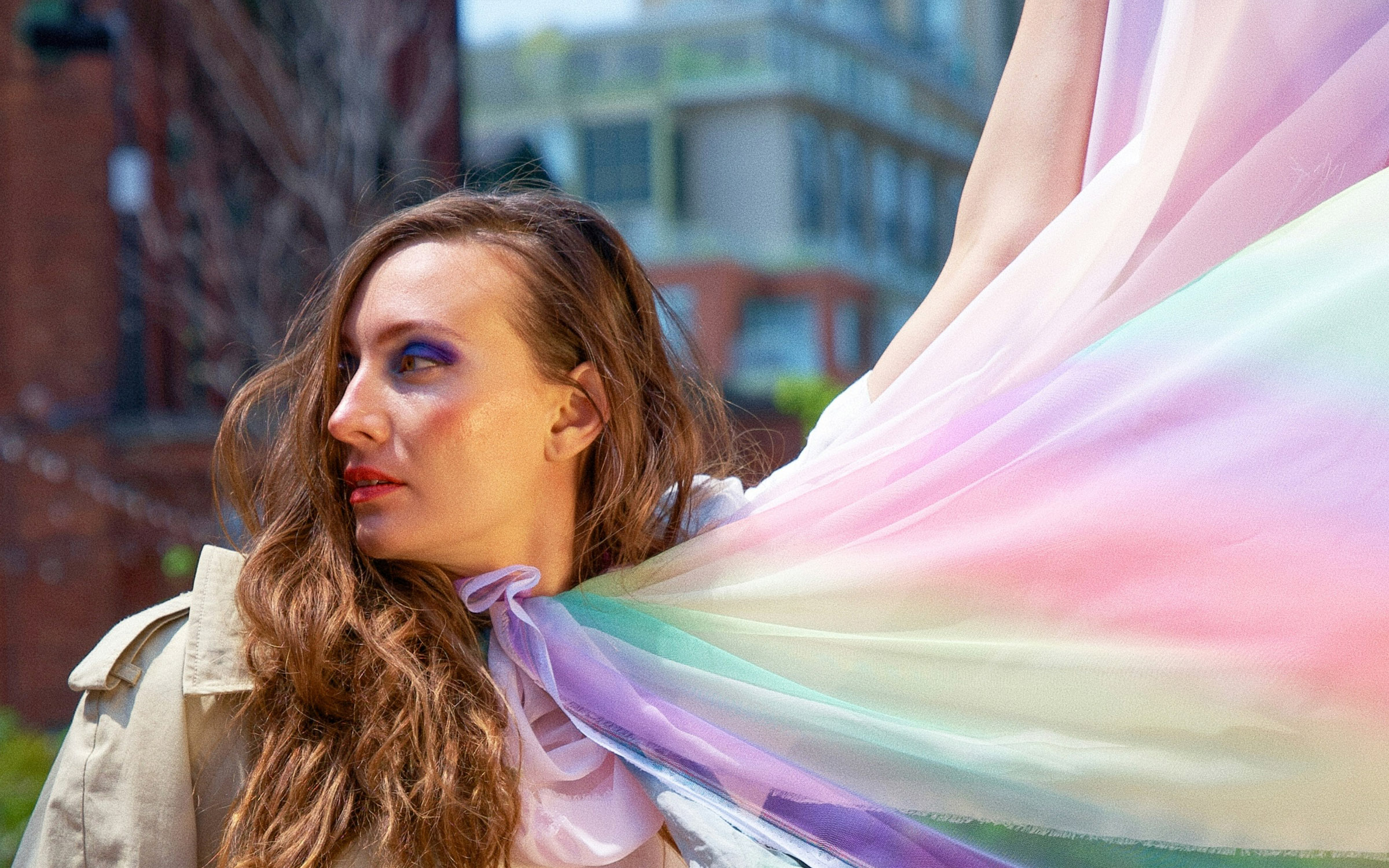 Person wearing flowing rainbow fabric, representing an inclusive and welcoming environment for LGBTQ+ clients.