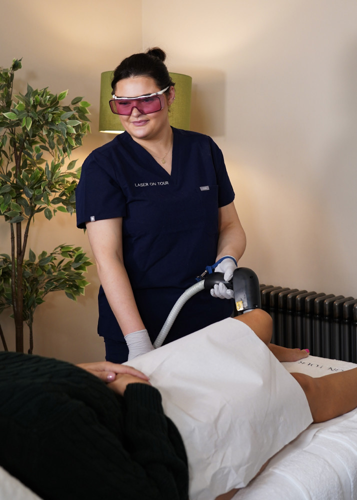 One of Laser On Tour's laser specialists administering laser hair removal on a customer's legs in their own home.
